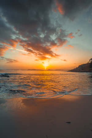 海上夕陽，沙灘上的海浪，戲劇性的雲層