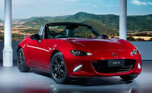 紅色Mazda MX-5 Miata開篷車以山景為背景展示。