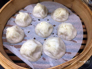 竹蒸籠內的新鮮蒸餃子，附有烘焙紙。