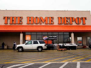 白色SUV停在Home Depot商店前，有橙色標誌和黃色停車線。