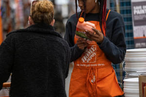 Home Depot員工協助顧客選擇油漆。