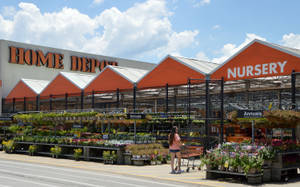 女性在陽光明媚的日子在 Home Depot 苗圃選購花卉