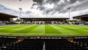 Craven Cottage 足球場,在陰天天空下,綠色草坪和空蕩蕩的看台。