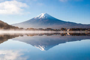 富士山倒映在霧氣瀰漫的湖泊中，天空清澈湛藍 — 湖景 壁紙