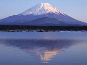 白雪覆蓋的富士山倒映在日出時的寧靜湖面上。 — 黎明 壁紙