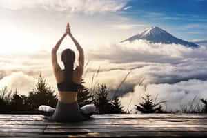 人在木製平台上以瑜伽姿勢冥想，下方有富士山和雲海。