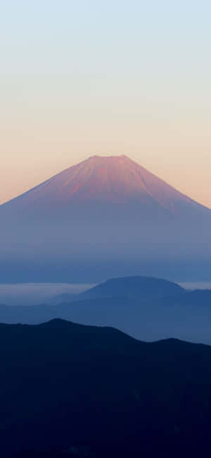 日出時的富士山，下方有霧氣層層的山脈 — Pixel 10 Pro XL 壁紙