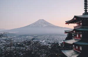 從寶塔眺望黎明時分霧氣籠罩的城市上方的雪覆蓋富士山 — 日本 壁紙