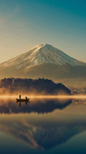 日出時分，兩人在霧氣瀰漫的湖上划船，富士山倒映在水中。 — 日本 壁紙