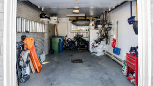 一個堆滿單車、工具和儲物箱的車庫。