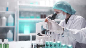 穿著實驗裝備的科學家用顯微鏡檢查樣本。