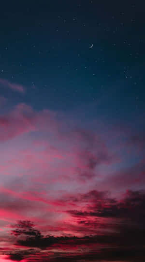 星光閃爍的暮色天空中，鮮豔的粉紅雲彩和一彎新月。