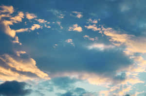 柔和藍色和金色雲彩在寧靜的日落天空中發光。