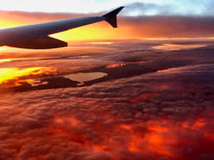 飛機機翼在雲層之上，閃爍著夕陽的色彩，照耀著大地。