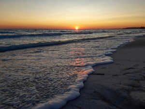 海洋上的夕陽，海浪沖刷沙灘