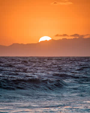 海上日落，遠方有山