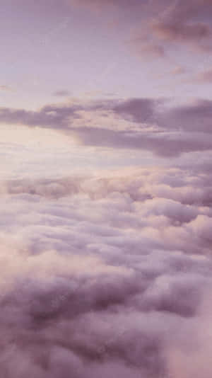從上方觀看，暮色天空下柔和的紫色和粉紅色雲海。