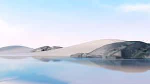 柔和天空下，平靜藍色海水中倒映的沙漠沙丘