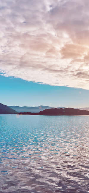 日出時分的寧靜湖泊，有山脈和粉彩天空 — Honor GT 壁紙