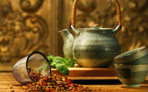 木桌上的陶瓷茶壺和杯子，配有乾香草。 — 設計 壁紙