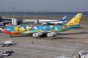 在機場停機坪上，裝飾有寶可夢角色的彩色ANA飛機。