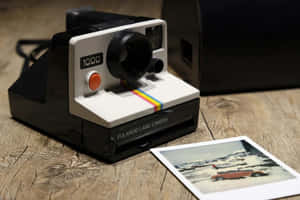 Polaroid相機，附有雪中汽車的即影即有照片，木質表面