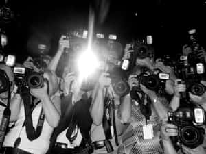 攝影師在夜間活動中帶著相機和閃光燈。