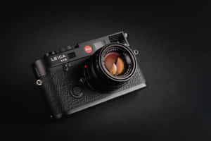 黑色 Leica M6 菲林相機在深色背景上，帶有鏡頭反射。