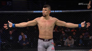UFC拳手在八角籠中張開雙臂慶祝勝利。