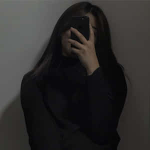 光線昏暗下，人拿著電話遮臉靠著素牆。 — 可愛情侶 GIF 壁紙