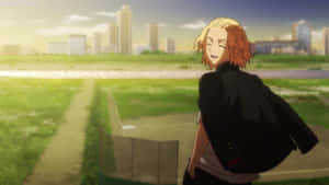 橙色頭髮的動漫角色在靠近城市的草地上微笑。 — Mikey 東京復仇者 GIF 壁紙