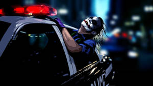 小丑在夜晚從警車中探出身子，紅色燈光閃爍。