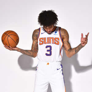 身穿Suns球衣的籃球運動員拿著球並做手勢。 — 籃球 壁紙
