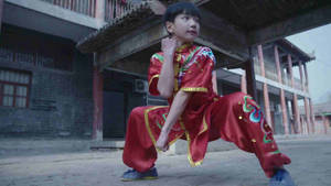 穿著紅色武術服的小孩在庭院練習姿勢