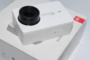 白色運動相機放在其產品盒上。 — Xiaomi 壁紙