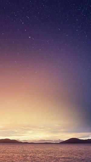 平靜海洋上空的星空暮色，地平線上有輪廓山丘 — Xiaomi 壁紙