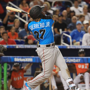 棒球手 Guerrero Jr. 在夜間比賽中揮棒。
