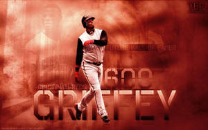棒球選手在火焰橙色背景上以「600」和「GRIFFEY」文字慶祝里程碑。 — 小肯·葛瑞菲 壁紙