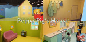 孩子們在Peppa Pig主題室內遊戲區玩耍，設有卡通屋牆和玩具廚房。