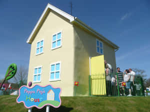 Peppa Pig的黃色房屋複製品，主題公園內有遊客。