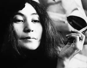 一名深色頭髮的女性在黑白肖像照中將香煙放在唇邊。 — 復古gif 壁紙