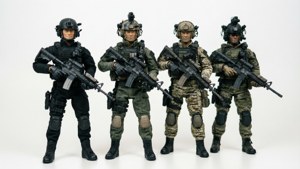 四名身穿戰術裝備的士兵手持步槍排成一排，背景為白色。