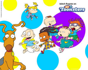 Rugrats 角色和他們的狗在色彩繽紛的圓點背景上玩耍。