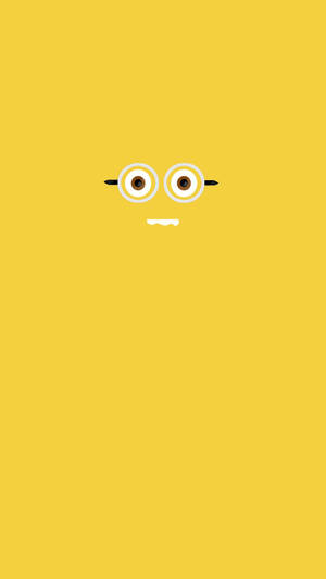 一個卡通Minion面孔，有大眼睛和眼鏡，在純黃色背景上。 — 簡約風格 壁紙