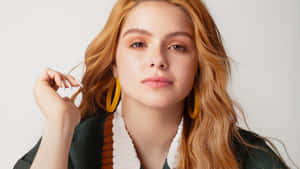 紅髮黃耳環的年輕女性工作室肖像。
