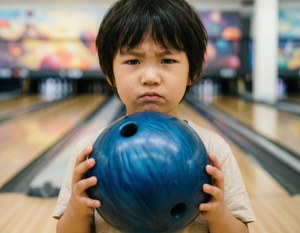 小孩在保齡球道上拿著藍色保齡球，表情專注 — 保齡球 壁紙