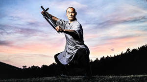 武術家在暮色中的草地上揮舞雙節棍 — 崔宇植 GIF 壁紙