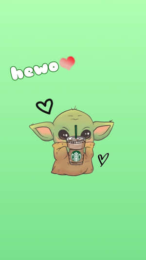 Grogu拿著一個星巴克杯子，上面有心形和「hewo」文字，背景為綠色。