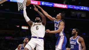 湖人球員在NBA比賽中越過76人防守球員入樽。