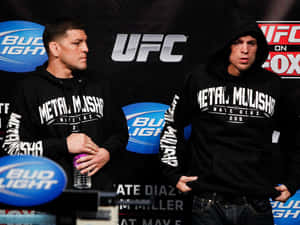 兩名男性MMA拳手在UFC記者會上穿著黑色連帽衫。